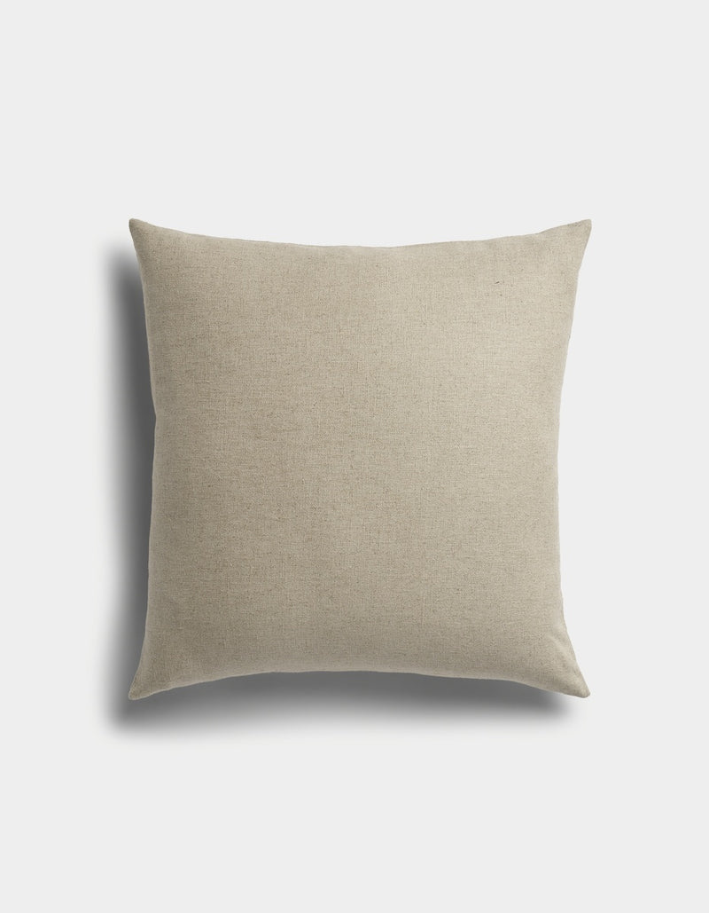The Sonoma Throw Pillow by Cozy Earth is a square beige cushion with a plain fabric cover, displayed against a white background featuring a faint shadow on the left side.