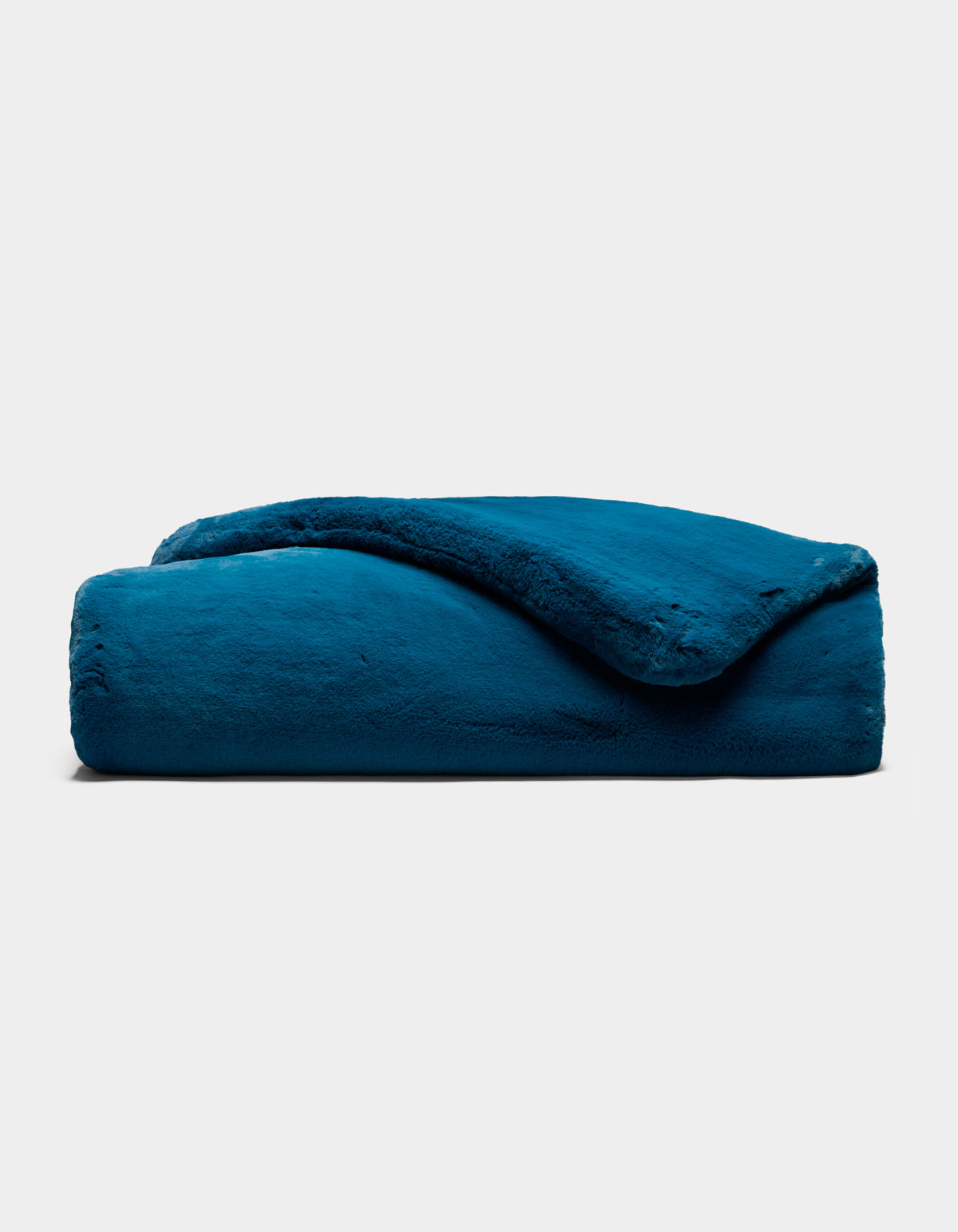 The Cozy Earth Superplush Cuddle Blanket is neatly folded and showcased against a plain light gray background, with one corner gently flipped to reveal its soft, plush texture.
