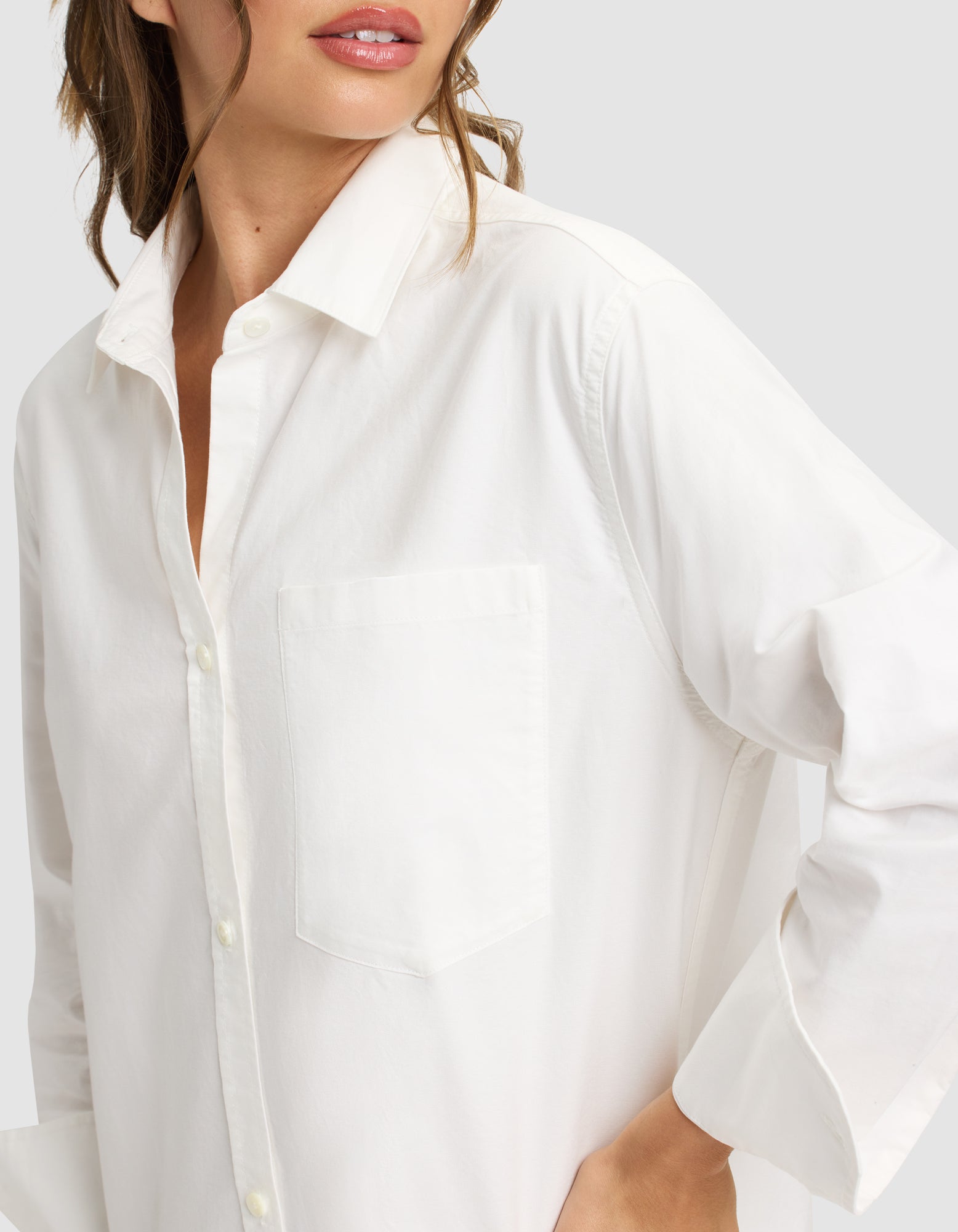 A woman models the Cozy Earth Women's Camden Midi Dress, standing with one hand on her hip against a light gray background. Her face is partially visible, showing only her lips and chin. 