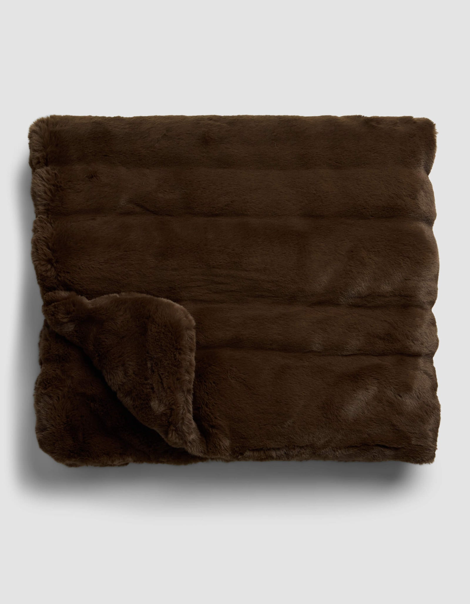 The Cozy Earth Channel Cuddle Blanket, shown folded with one corner turned over, features soft, plush dark brown faux fur and is displayed on a light gray background.