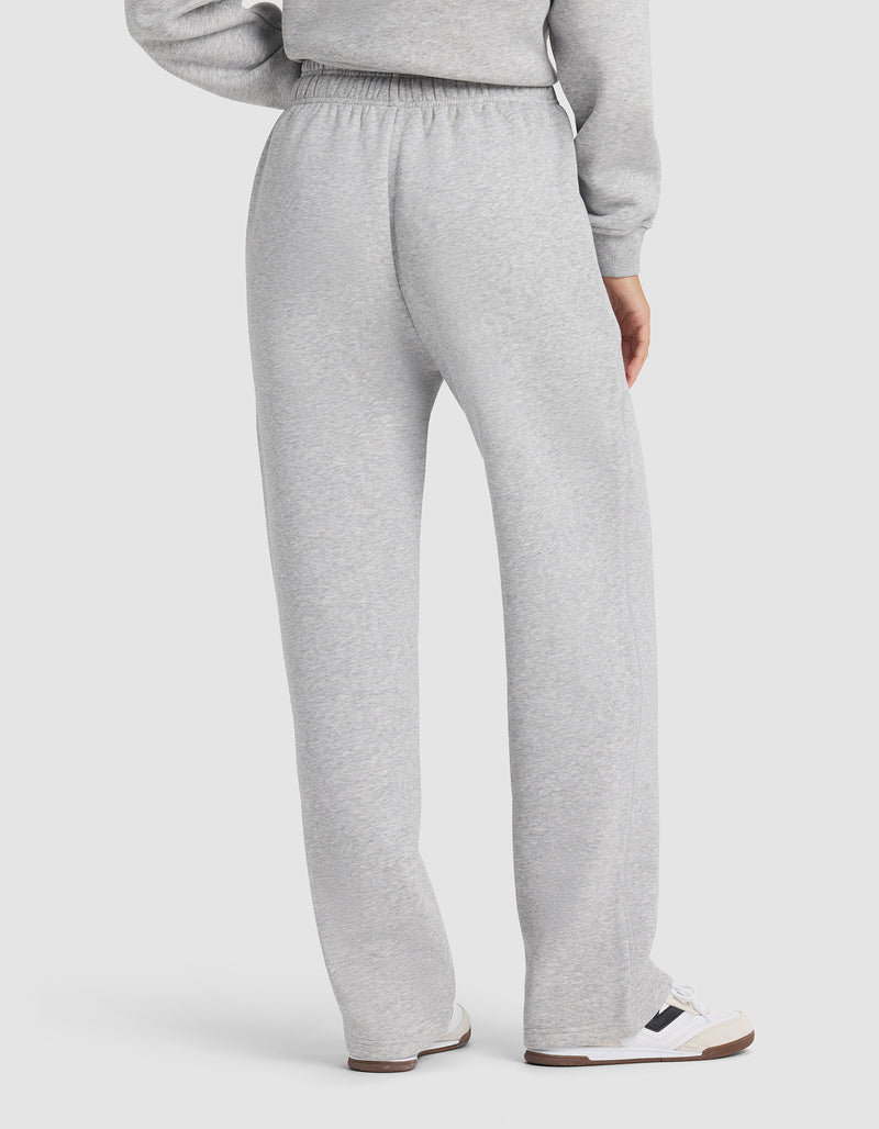 Seen from the back, a person wears Cozy Earth's Women's Cityscape 2.0 Wide Leg Pant in light gray with a matching sweatshirt and white sneakers with dark accents, set against a plain white background.