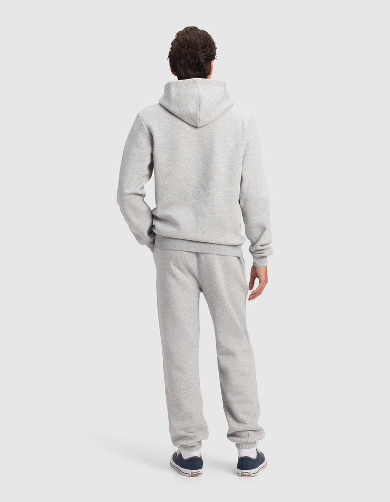 A person faces away from the camera in Cozy Earth's Men's Cityscape 2.0 Hoodie & Sweatpant Set, paired with dark sneakers, shown against a plain light background.