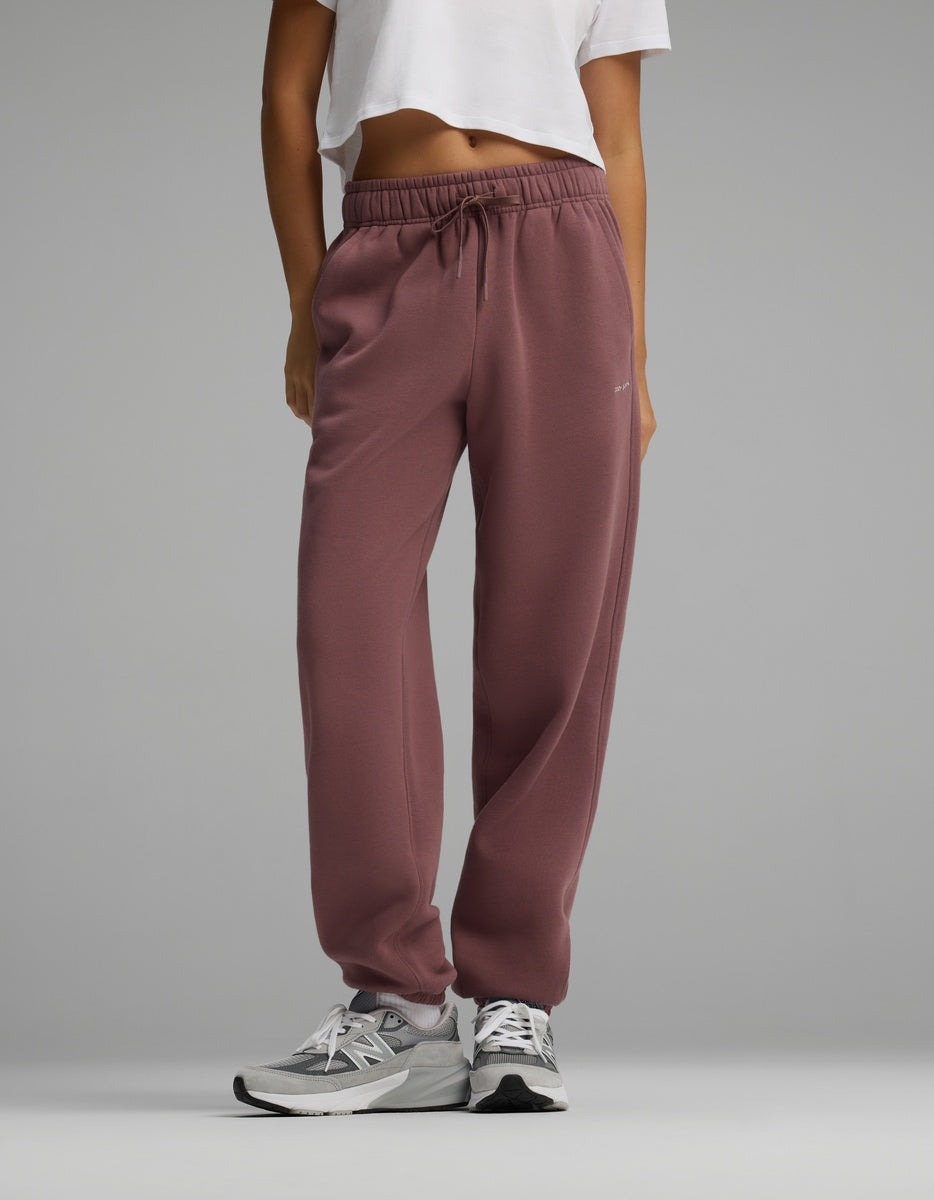 Person wearing mauve Women’s CityScape Sweatpant featuring a high-waisted drawstring design and elastic cuffs.