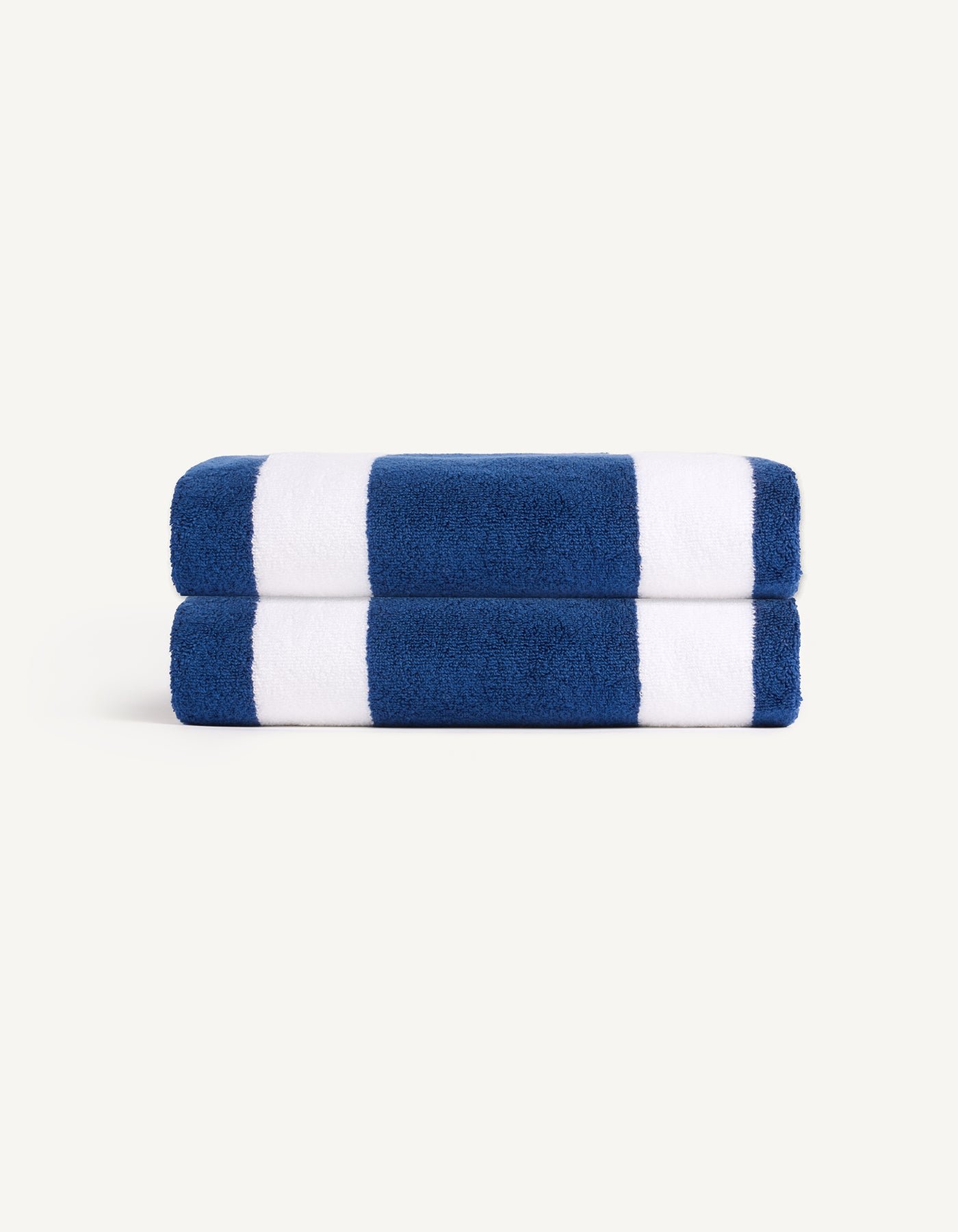 The Cozy Earth Classic Stripe Resort Towel Bundle features a folded towel with wide navy blue and white horizontal stripes, displayed against a plain, light background. |Color:Pacific