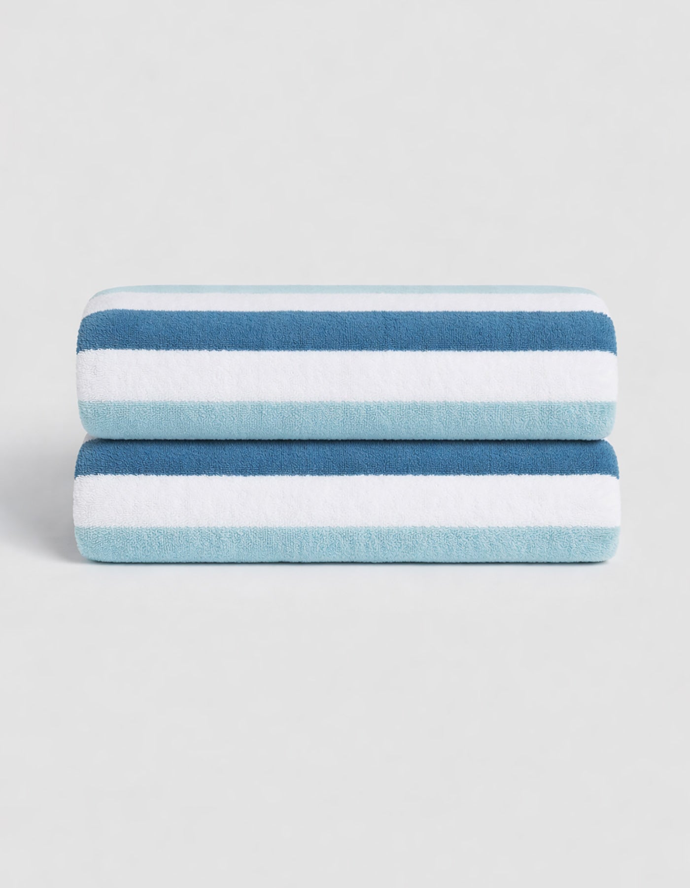 The Classic Stripe Resort Towel Bundle by Cozy Earth features two neatly folded towels with dark blue, light blue, and white stripes, stacked together against a plain light background.|Color:Lake Stripe
