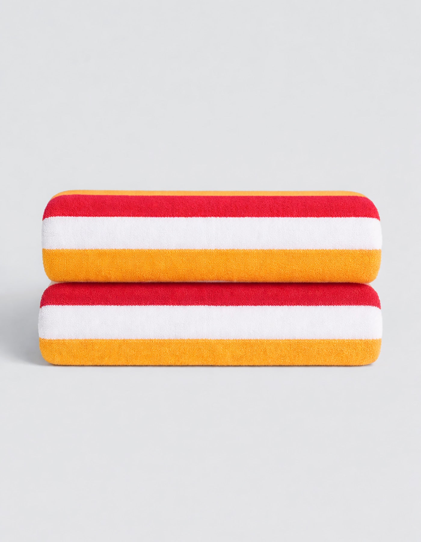 The Classic Stripe Resort Towel Bundle by Cozy Earth features two neatly folded towels with bold red, white, and yellow stripes, stacked on a simple light gray background.|Color:Mandarin Stripe