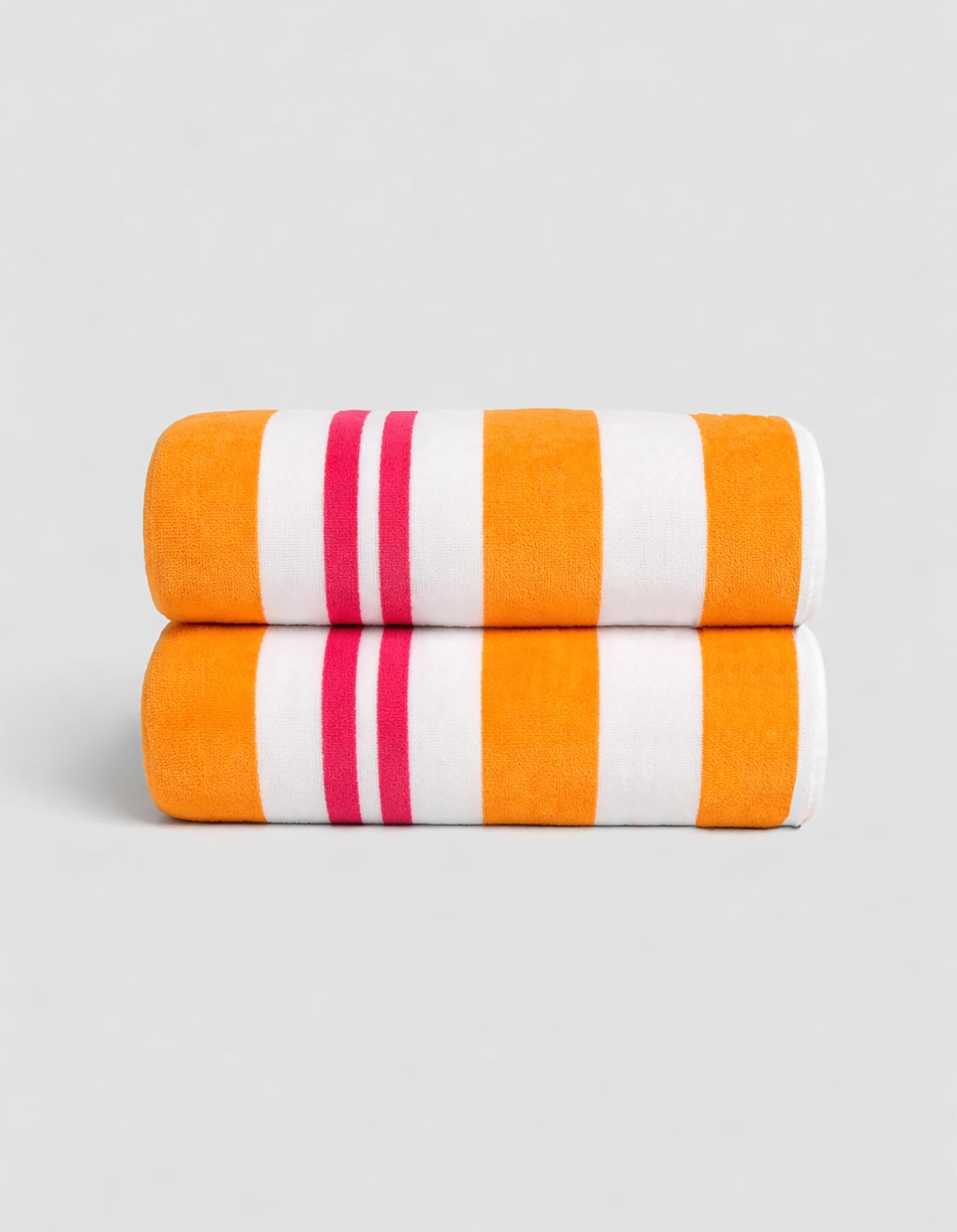 The Classic Stripe Resort Towel Bundle by Cozy Earth, in Picante Stripe, features two neatly folded towels with bold orange, white, and pink stripes stacked together against a plain light gray background.