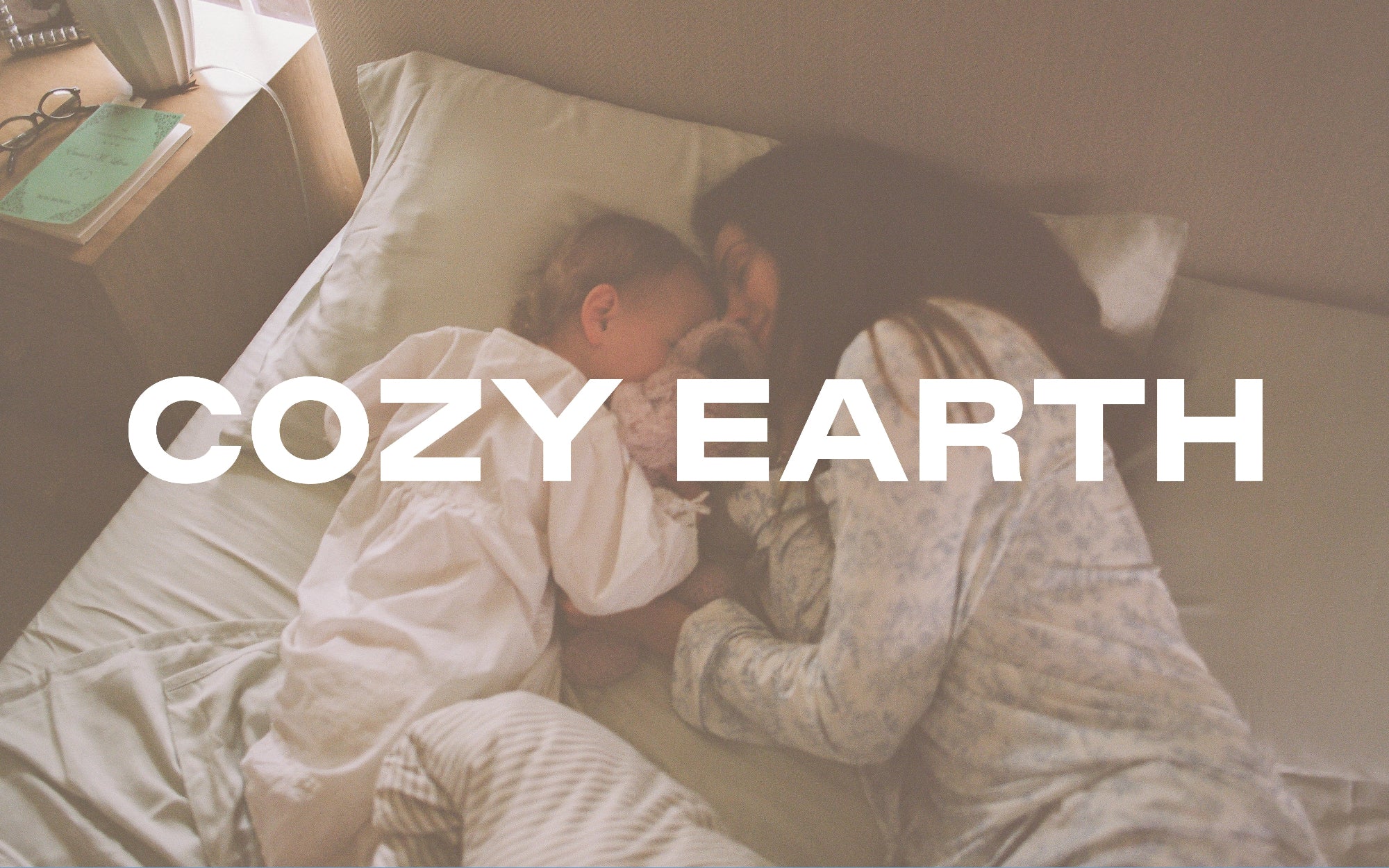 Two people lying in bed together with 'Cozy Earth' text overlay.