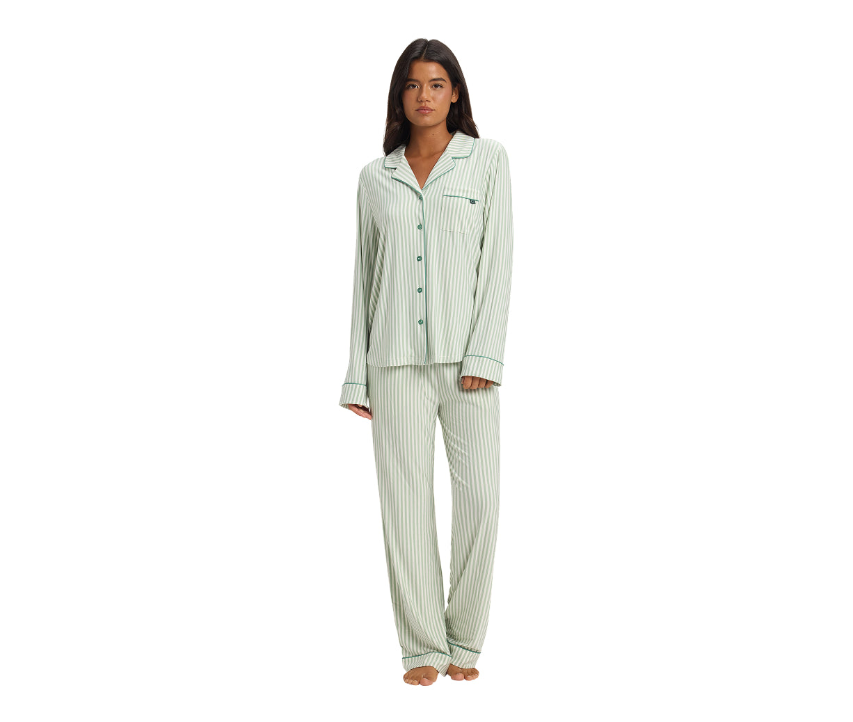 Woman wearing a green and white striped pajama set on a white background
