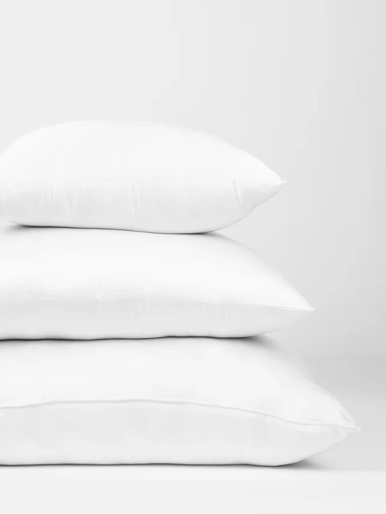 Stack of white pillows on a light gray background
