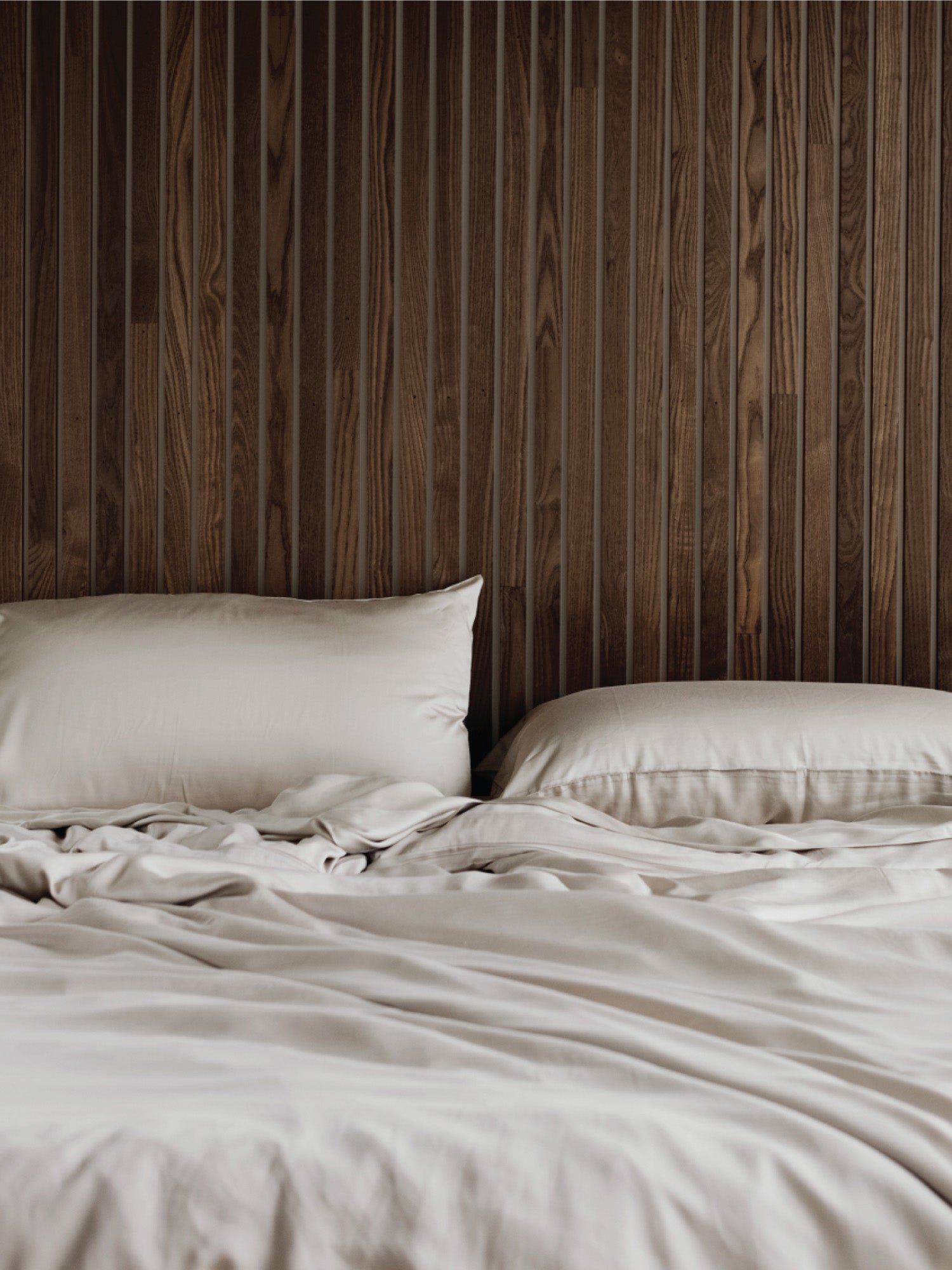 Driftwood pillows and duvet cover on an unmade bed 