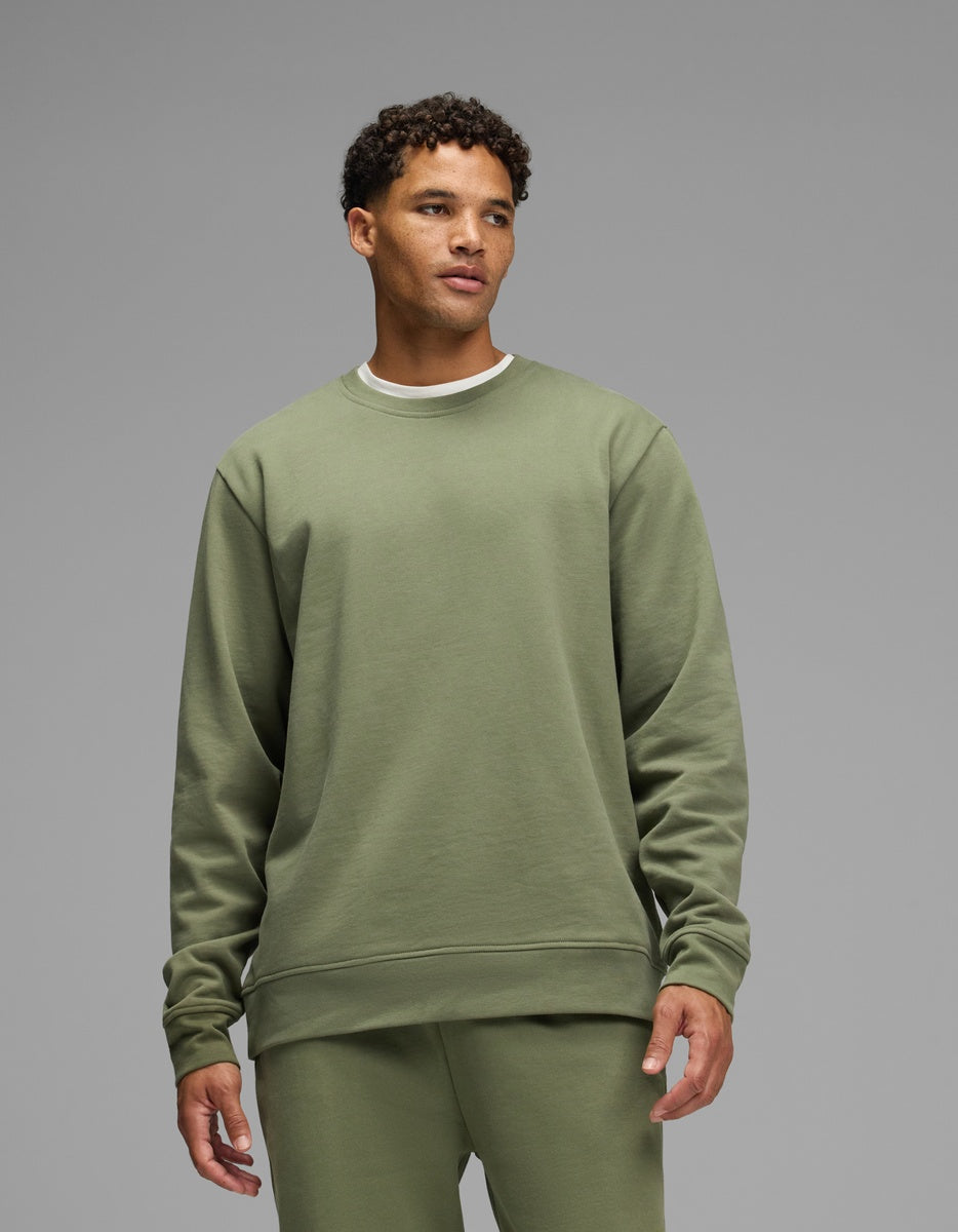 A man wears an olive green Men’s Dylan Crewneck over a white t-shirt.|Color:Marsh