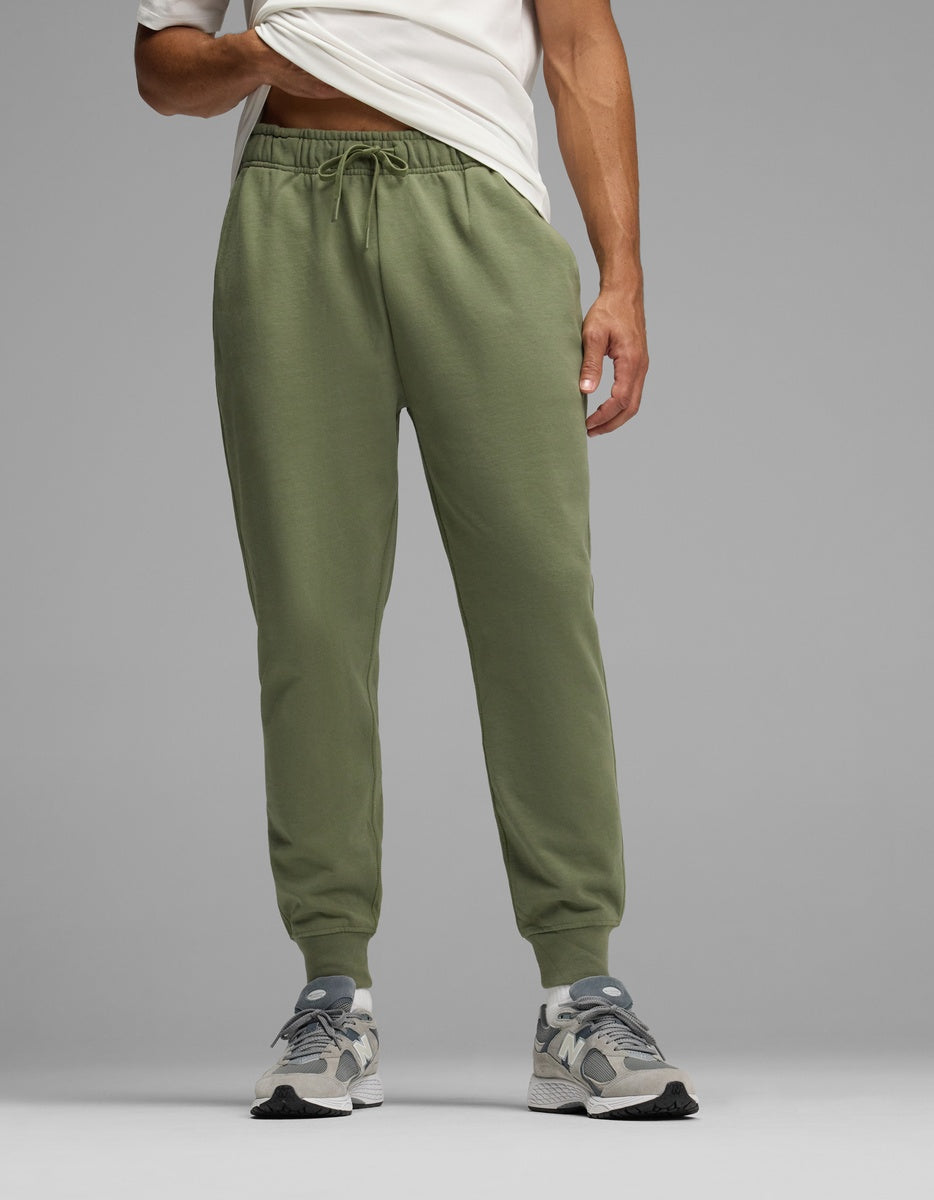 A person wearing olive green Men’s Dylan Jogger pants with an elastic drawstring waist and cuffed ankles.|Color:Marsh