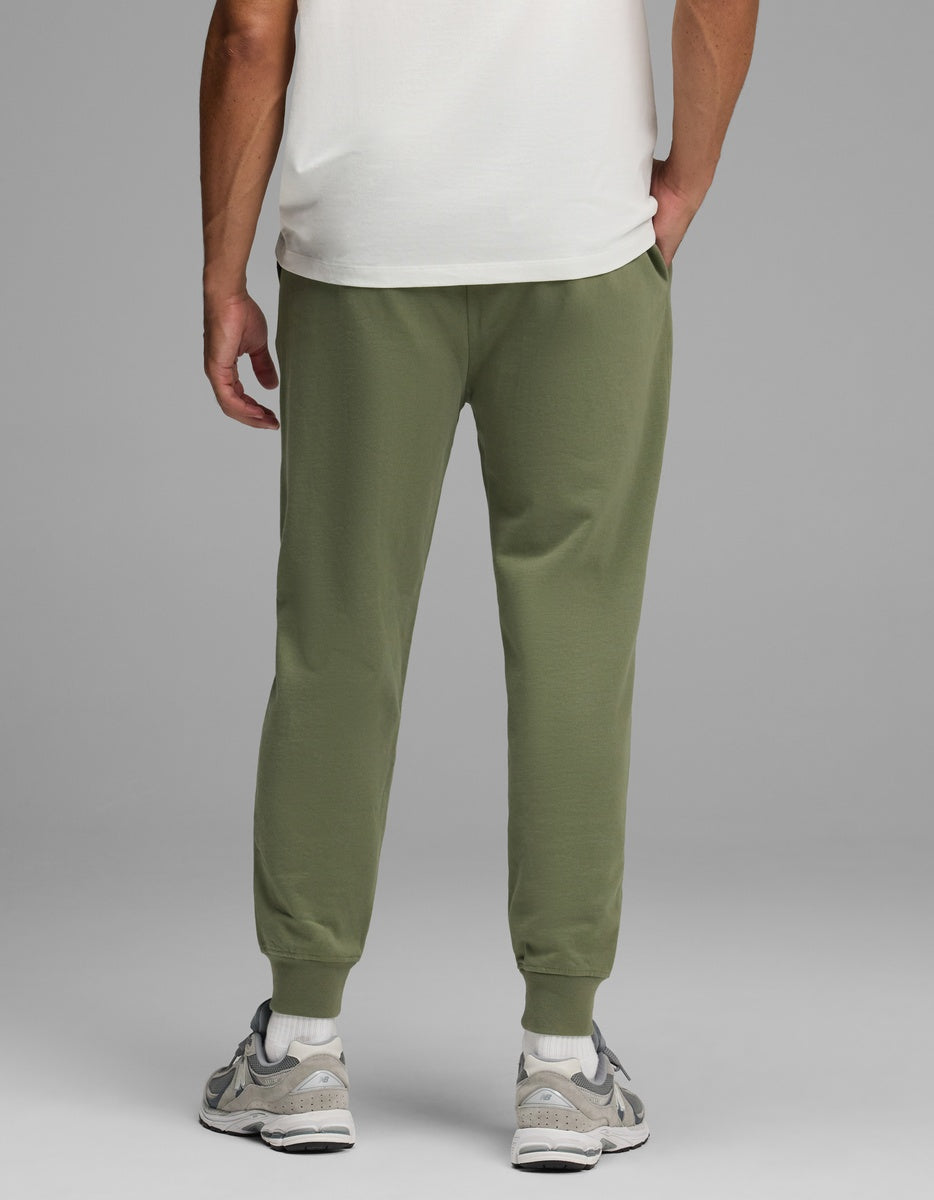 Back view of a person wearing olive green Men’s Dylan Jogger pants with ribbed ankle cuffs.