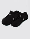 A pair of Women's Essential Ankle Socks by Cozy Earth in black, featuring white partial text "CO" and "TH" on top, displayed on a light gray background.|Color:Black