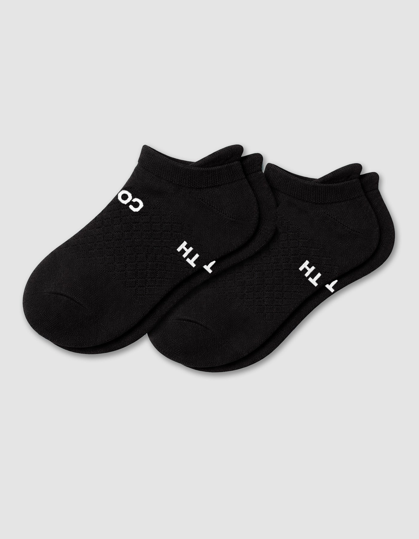 The Women's Essential Ankle Sock by Cozy Earth features a textured black design with subtle white text near the cuff, shown on a light gray background.