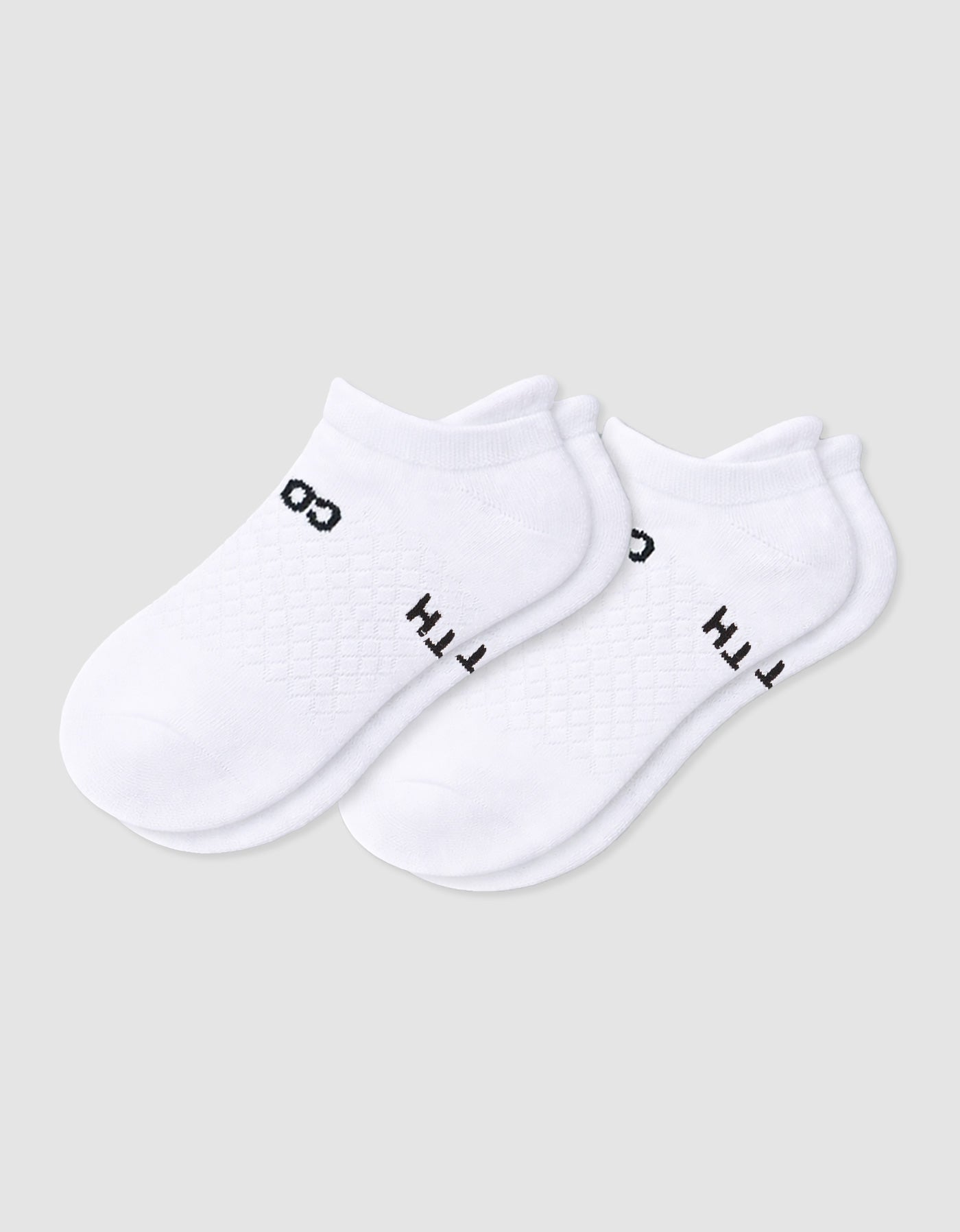The Women's Essential Ankle Sock by Cozy Earth features a textured white design with subtle black text near the cuff, shown on a light gray background.