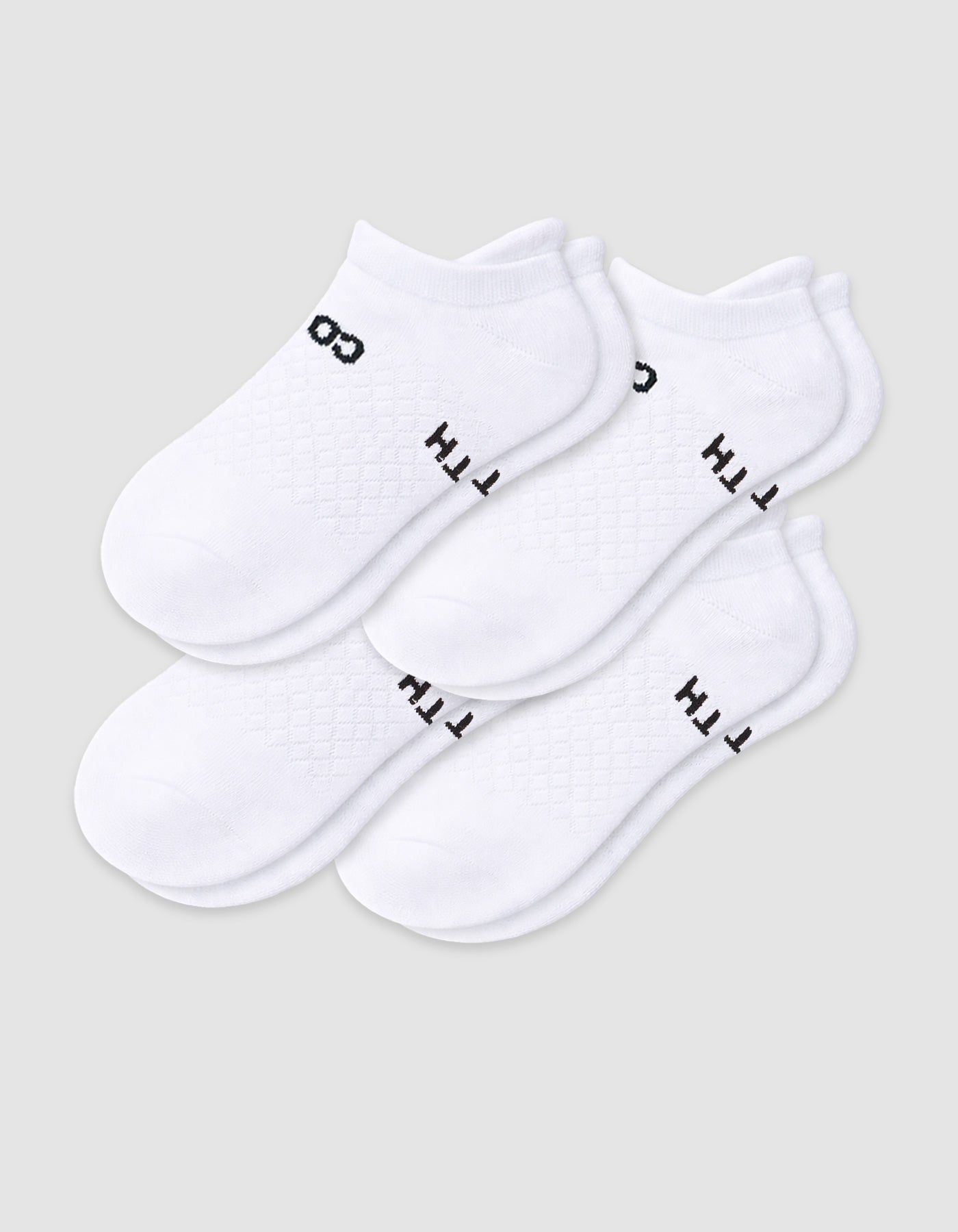 The Cozy Earth Women's Essential Ankle Sock 4-Pack features white ankle socks with black text and designs near the ankles, shown on a light gray background.|Color:White