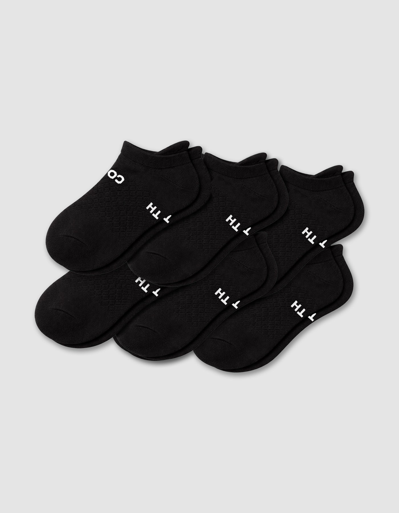 Six pairs of Cozy Earth Men's Essential Ankle Socks in black are neatly arranged on a light gray background, each featuring small white text near the toe.