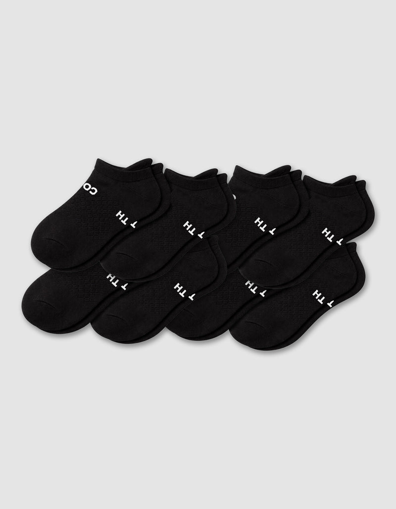Eight pairs of Cozy Earth Men's Essential ankle socks in black are arranged in two rows on a plain light gray background, with some showing white text near the cuff.