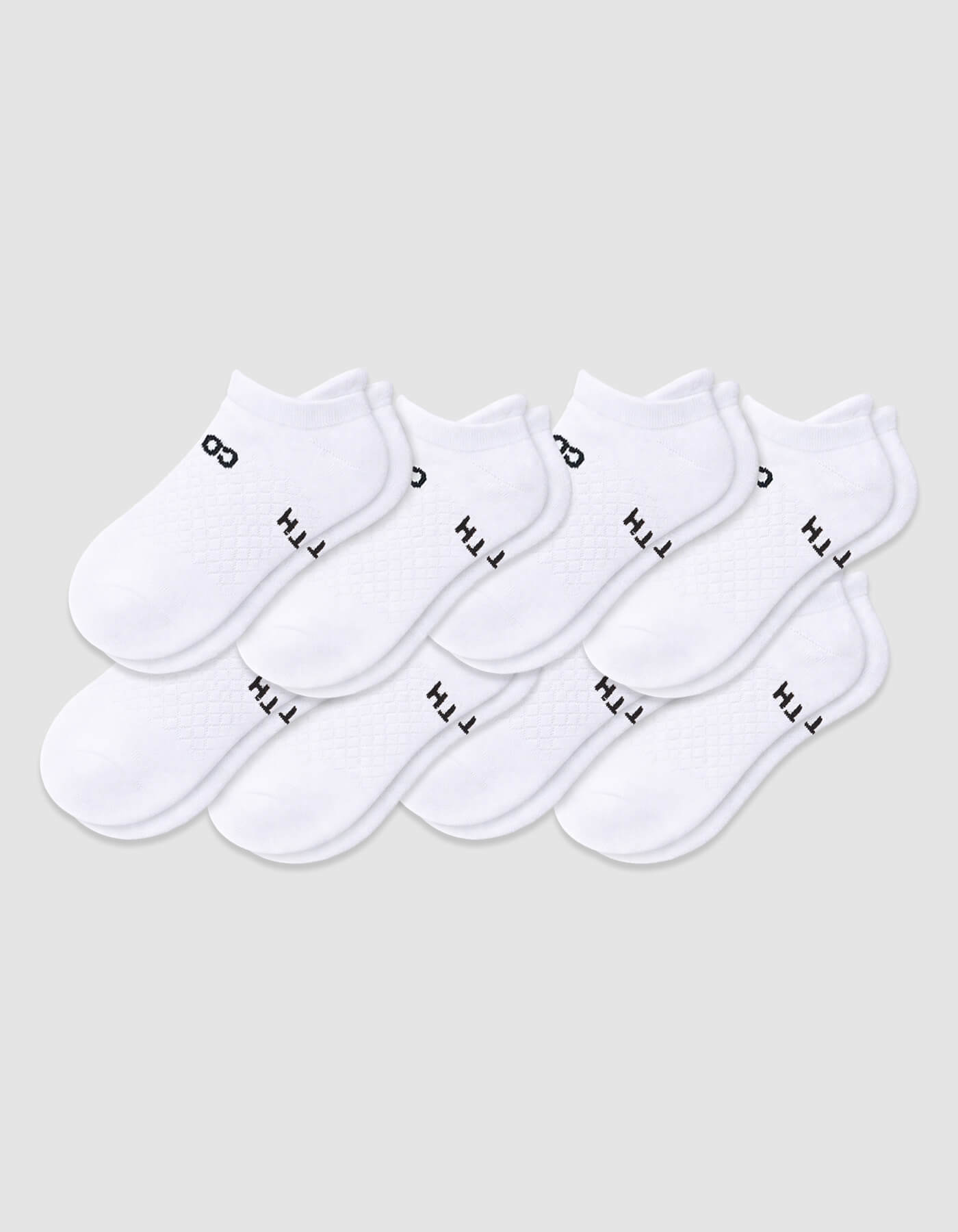 The Men's Essential Ankle Sock 8-Pack by Cozy Earth features white ankle socks displayed on a light gray background, each with black text on the sides.|Color:White