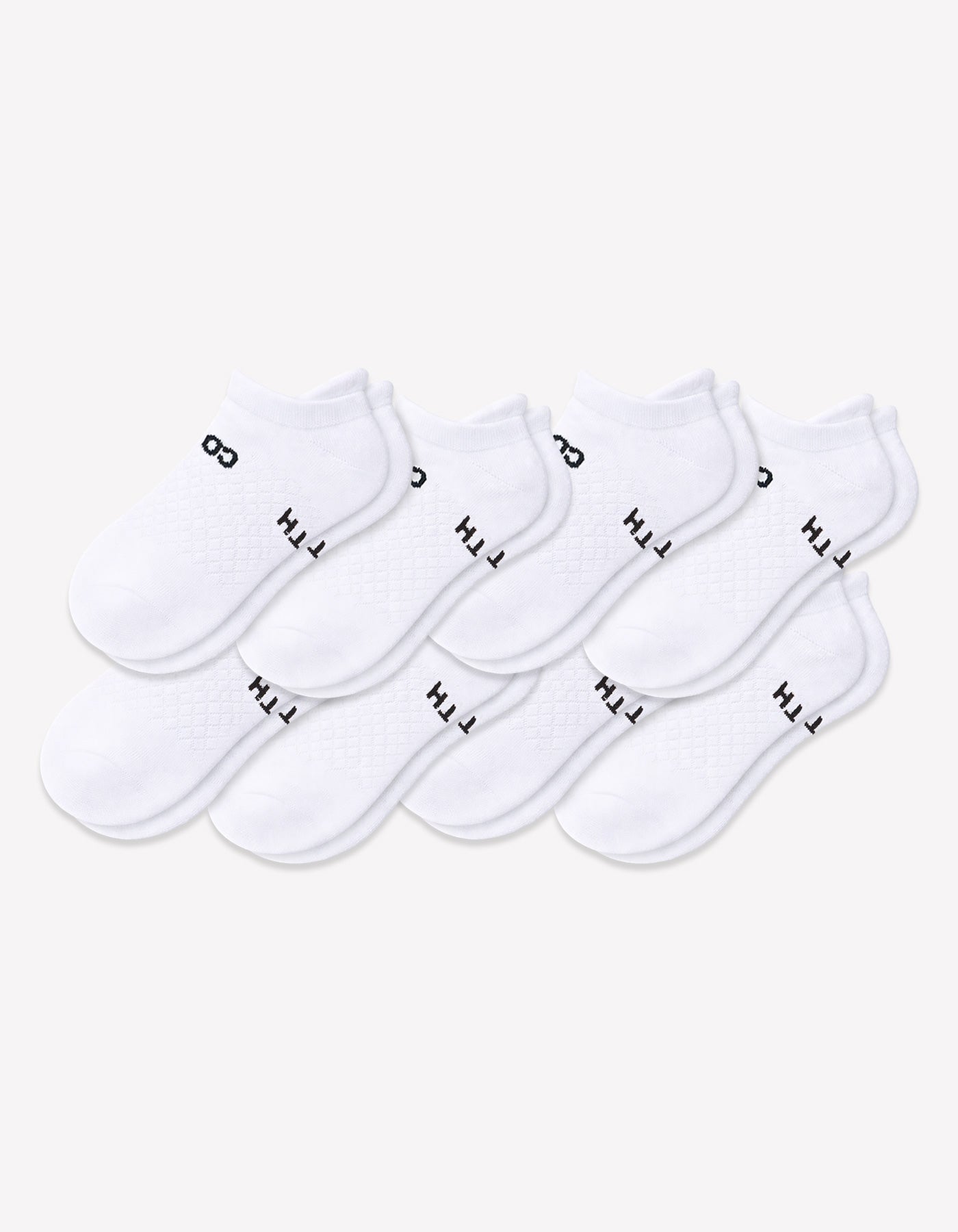 Eight pairs of Cozy Earth Men's Essential Ankle Socks in white are arranged in two overlapping rows, each featuring black text near the cuff. The socks are set against a plain, light-colored background.