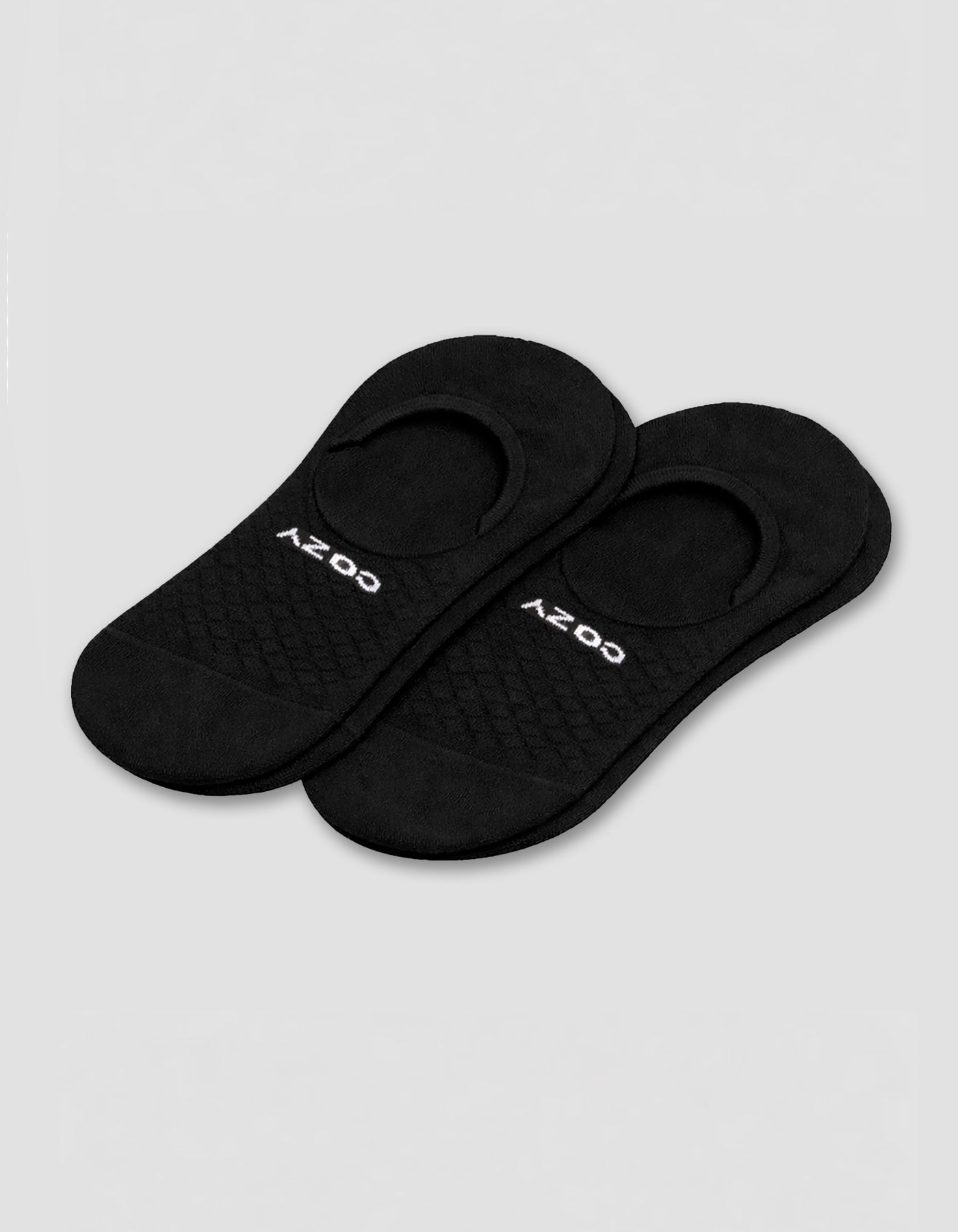 A pair of black Women's Essential No-Show Socks by Cozy Earth, featuring a textured pattern and the brand name in white near the toe, shown on a light gray background.