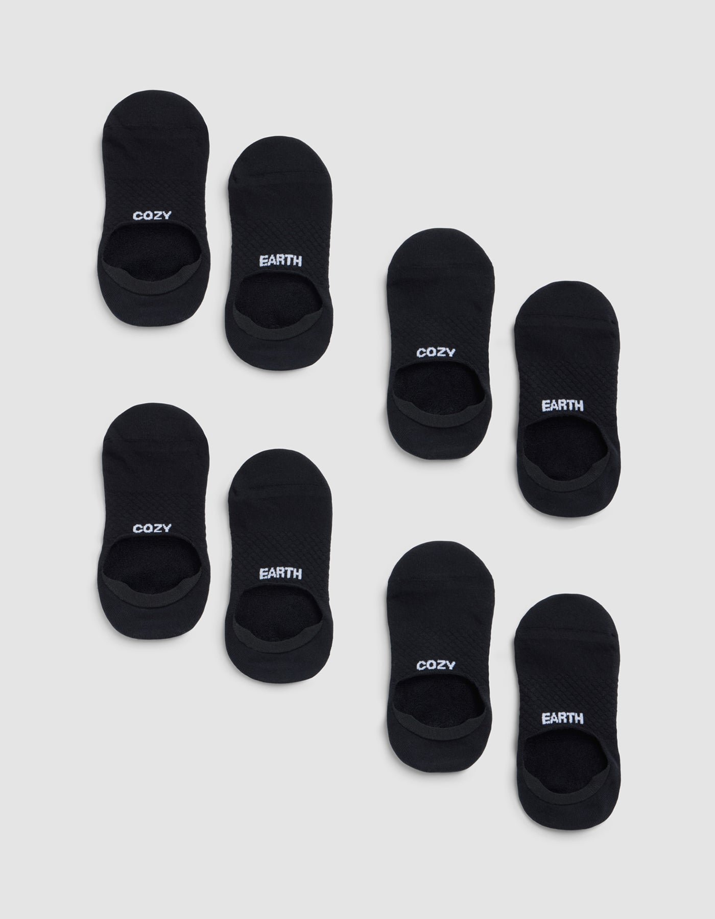Eight pairs of black Essential No-Show Socks from Cozy Earth on a light gray background—four pairs read "COZY" and four read "EARTH" in white lettering on top. |Color:Black