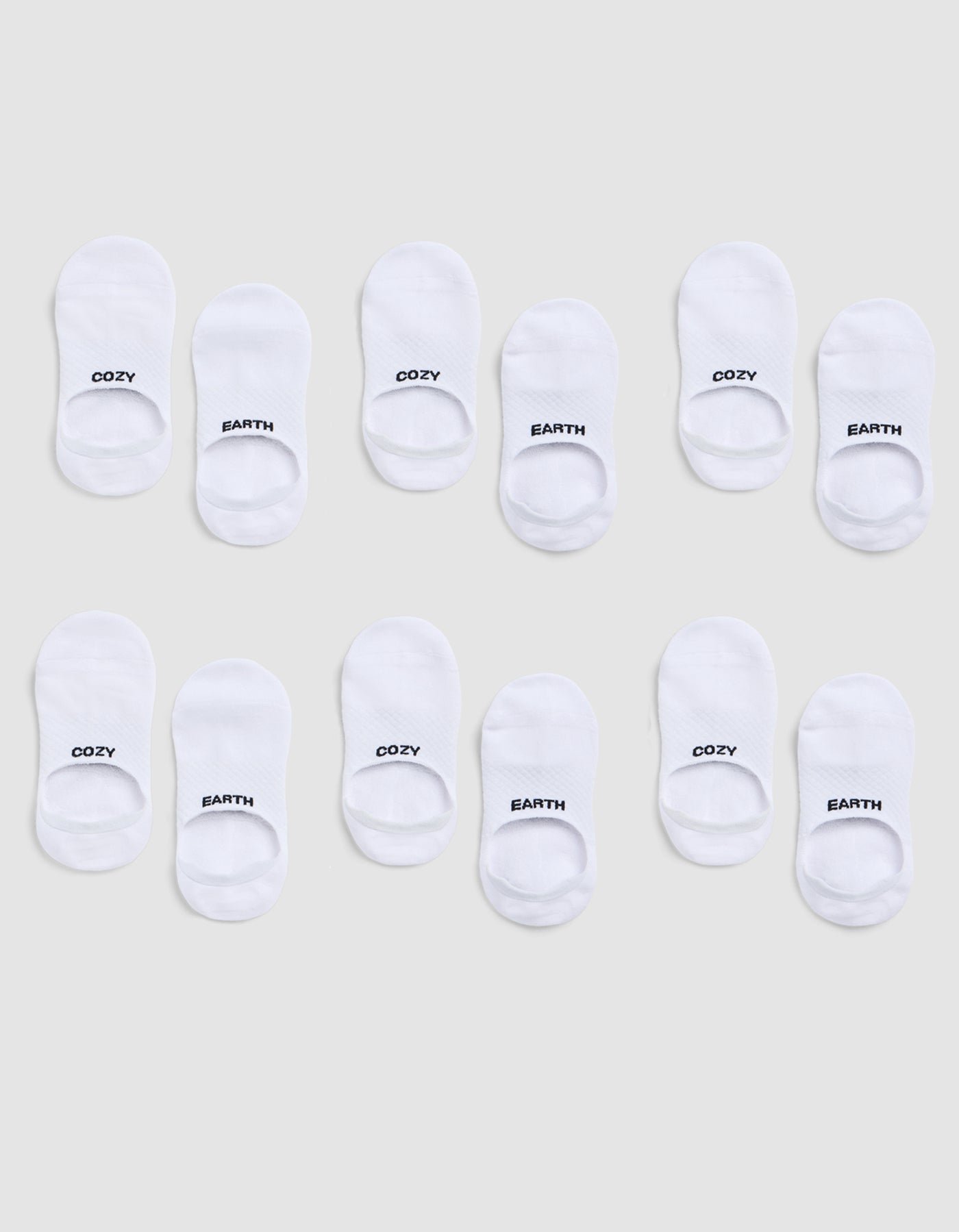 A 6-pack of white Essential No-Show Socks by Cozy Earth, each pair featuring "COZY" or "EARTH" in black text on top, displayed on a light gray background. |Color:White
