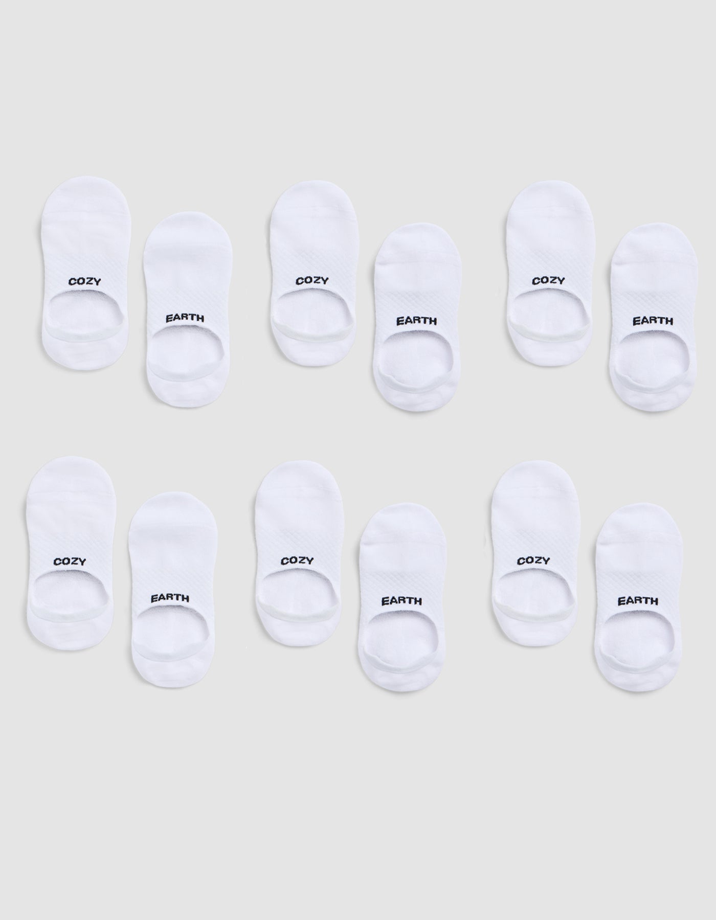 A 6-pack of white Essential No-Show Socks by Cozy Earth, each pair featuring "COZY" or "EARTH" in black text on top, displayed on a light gray background. |Color:White