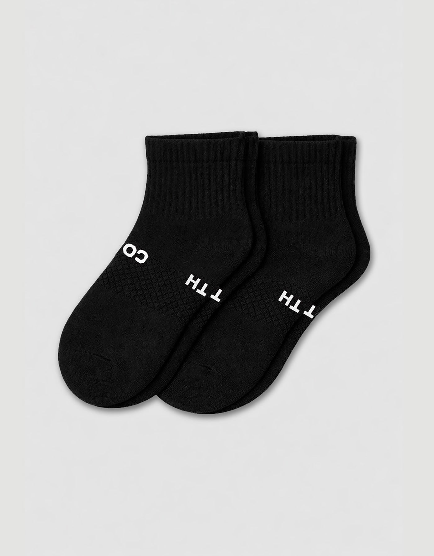 The Cozy Earth Men's Essential Quarter Sock features black ribbed cuffs and a discreet white text design on the sides, displayed against a plain light background.
