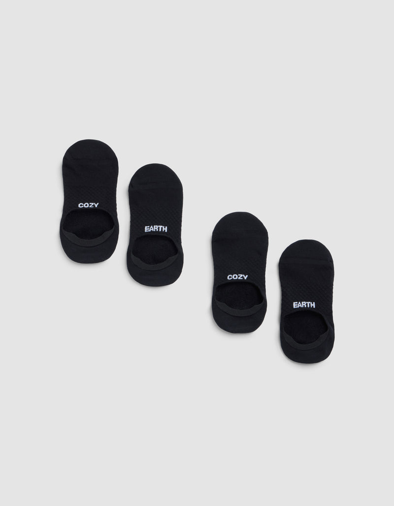 Two pairs of black Essential No-Show Socks by Cozy Earth are displayed on a light gray background. One pair features "COZY" in white lettering, and the other pair displays "EARTH" in white.