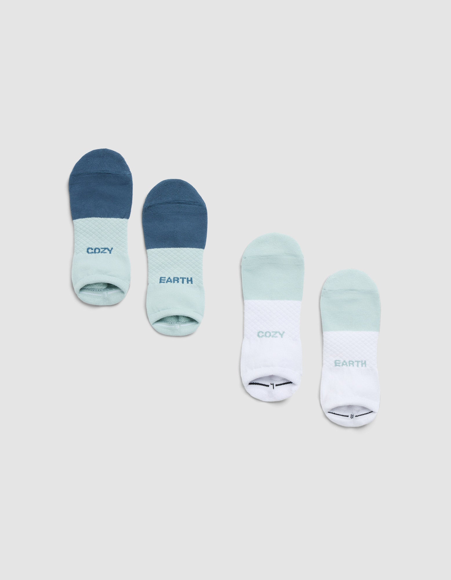 Four Cozy Earth Essential Ankle Socks are laid side by side: one pair in blue and light blue, the other in mint green and white, each with "COZY" and "EARTH" printed on them. 