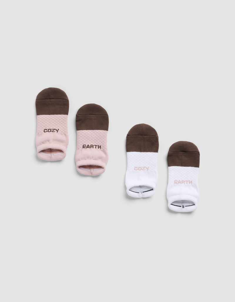 Four pairs of Cozy Earth Essential Ankle Socks are arranged in a row—two pink/brown and two white/brown, each featuring "COZY" and "EARTH" text—displayed on a light gray background.