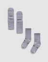 Two pairs of Essential Calf Socks by Cozy Earth are displayed on a white background—one pair folded to show "COZY" and "EARTH," the other flat with the same words visible on the soles.|Color:Stone