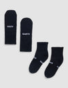Four Essential Quarter Socks by Cozy Earth are laid out flat on a light background. Two display "COZY" and "EARTH" in white text, while the other pair shows these words partly visible near the toes. |Color:Black