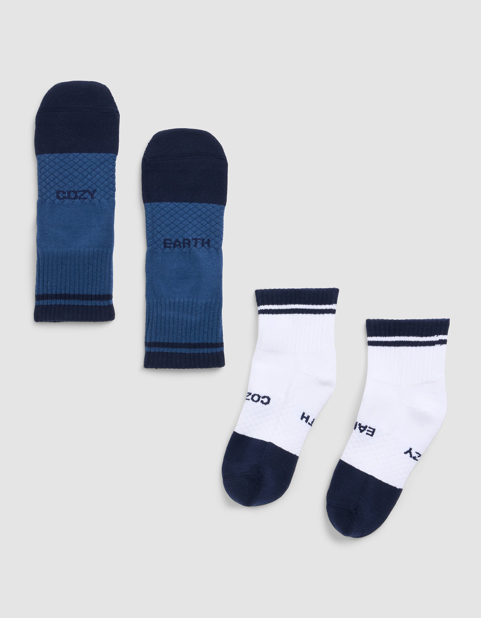 The Cozy Earth Essential Quarter Sock includes two pairs: one blue with navy toes, heels, and cuffs, and one white with navy accents. Both feature the words "COZY" and "EARTH. |Color:Eclipse