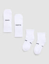 Four white Essential Quarter Socks from Cozy Earth are laid flat on a light gray background. Each features black text: one pair reads “COZY” and “EARTH,” while the other’s text shows parts of “EARTH,” “COZY,” and “OZY.”.  |Color:White