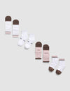 A diagonal row of six pairs of Essential Quarter Sock 4-Packs by Cozy Earth in brown, white, and pink on a light gray background. Some socks feature printed text like "COZY," "EARTH," |Color:Cedar
