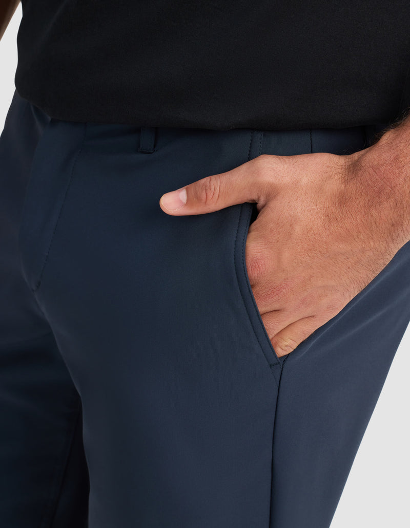 A close-up of a person wearing Cozy Earth Men's Everywhere Short in dark blue and a black shirt, with their right hand placed inside the short’s pocket.