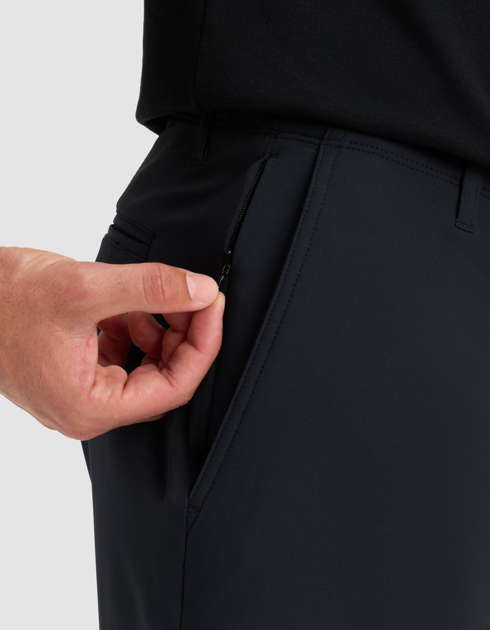 A hand pulls the zipper on a side pocket of Cozy Earth's Men's Everywhere Short, with a close-up focus on the pocket area.