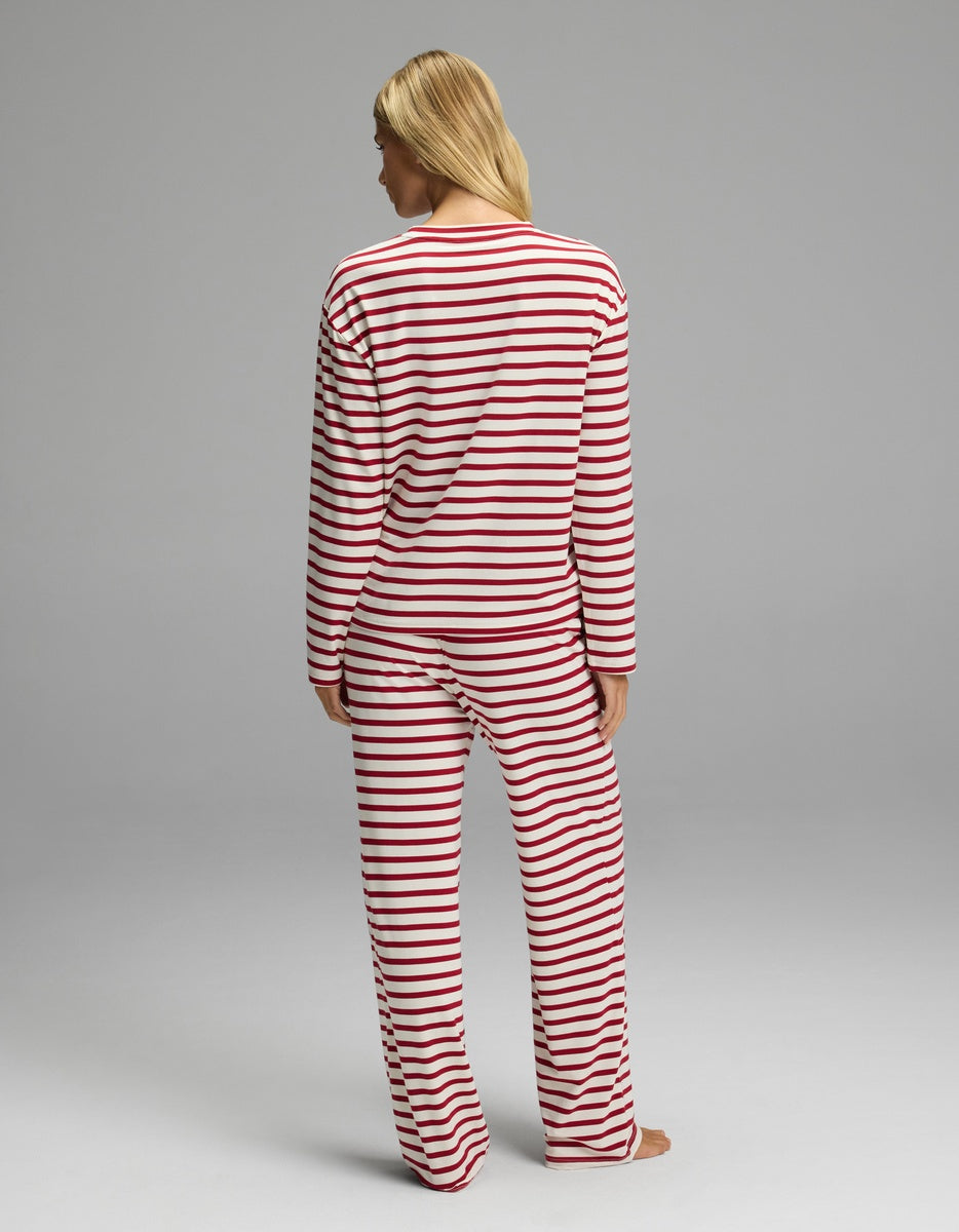 A woman seen from behind wearing a Cozy Earth Women’s First Layer Long Sleeve Sleep Tee & Pajama Pant Set with a red and white horizontal stripe pattern.