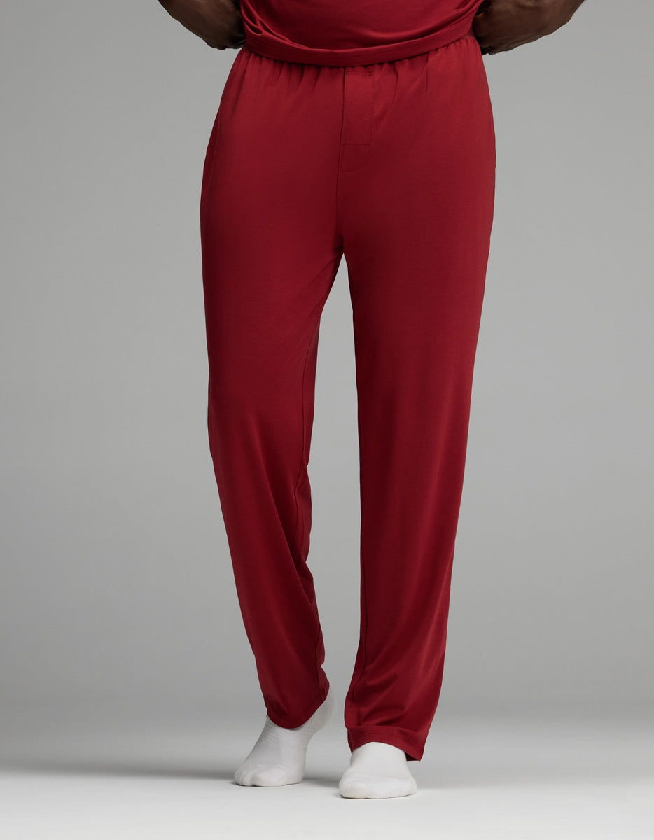 A person wearing dark red Cozy Earth Men’s First Layer Pajama Pant and white socks.