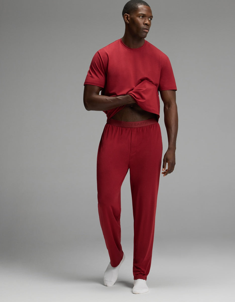 A man wearing a red t-shirt and matching red Men’s First Layer Pajama Pant.