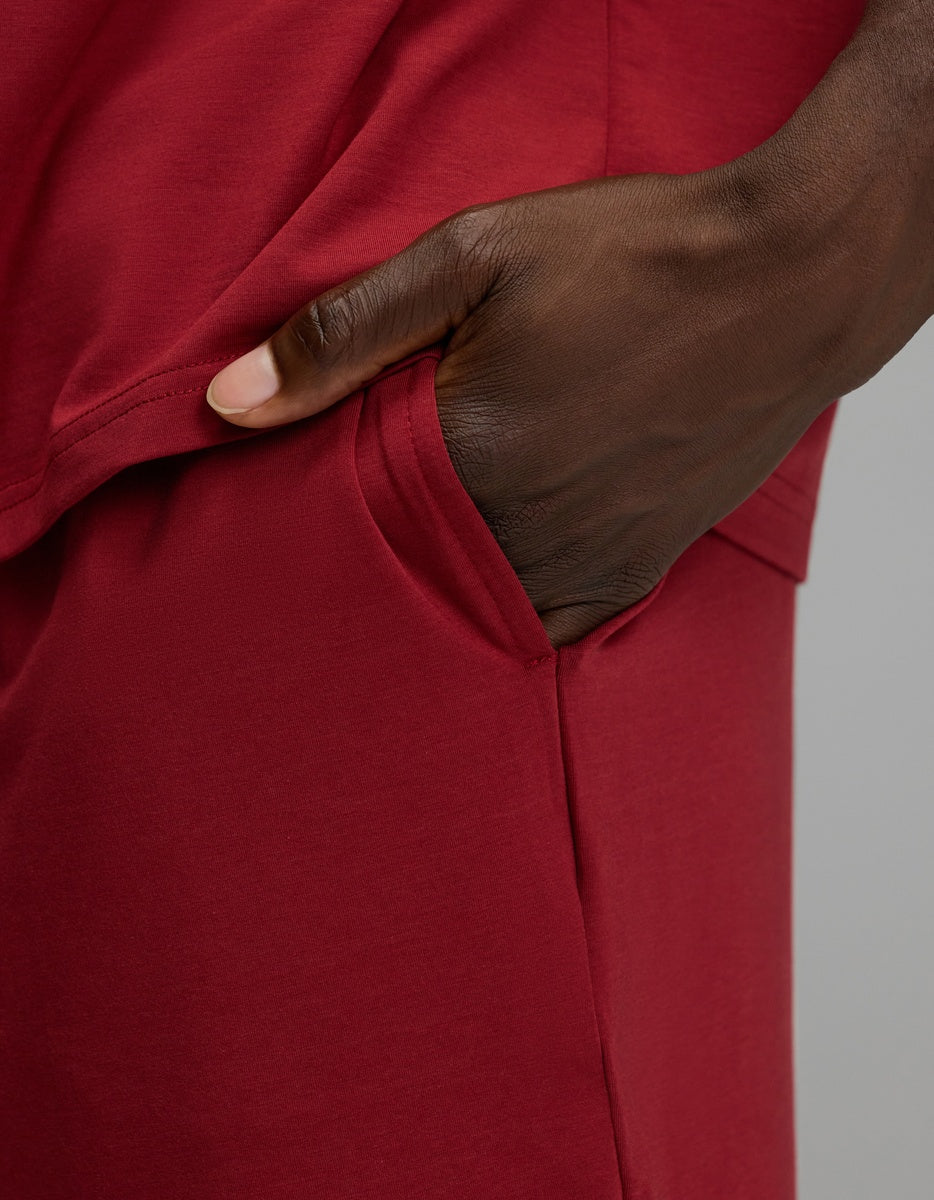A hand resting in the pocket of maroon Men’s First Layer Pajama Short.
