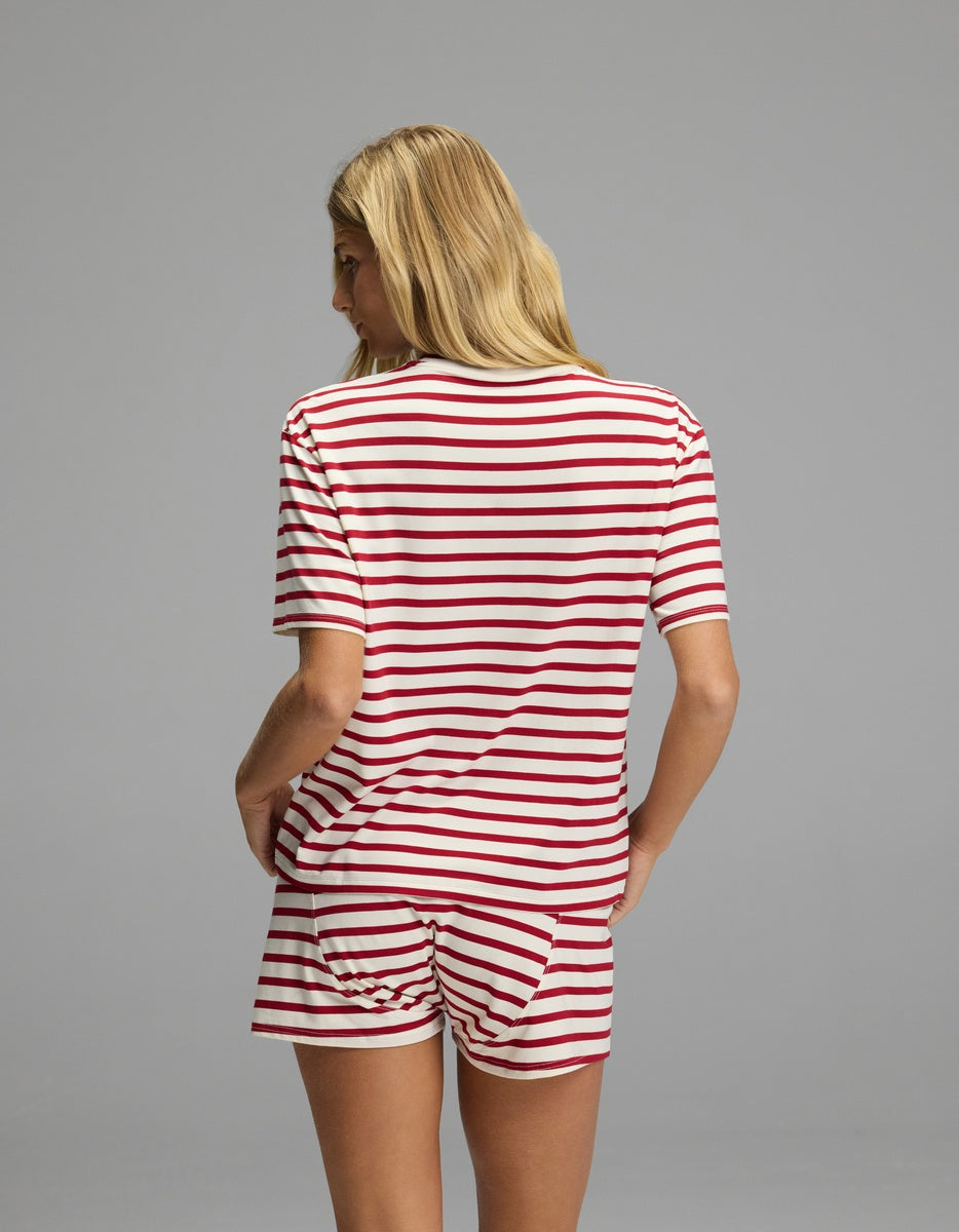 A person seen from behind wears a Cozy Earth Women’s First Layer Pajama Short Sleeve Tee & Boxer Short Set in white with horizontal red stripes.