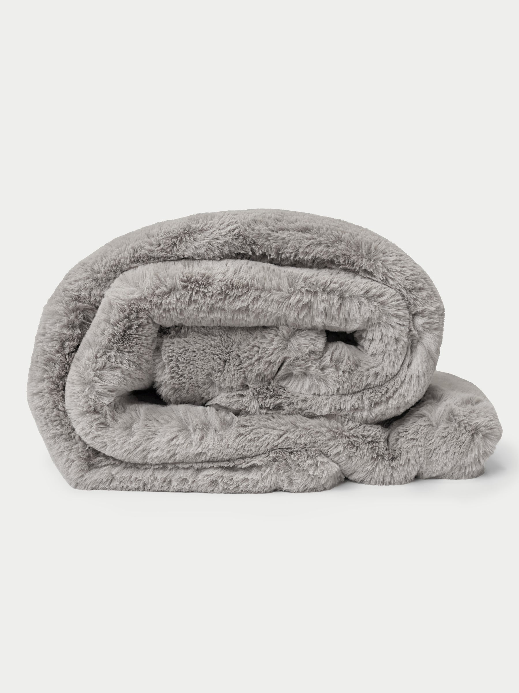 A rolled-up, plush Cuddle Blanket from Cozy Earth in gray faux fur on a plain white background. |Color:Dove Grey