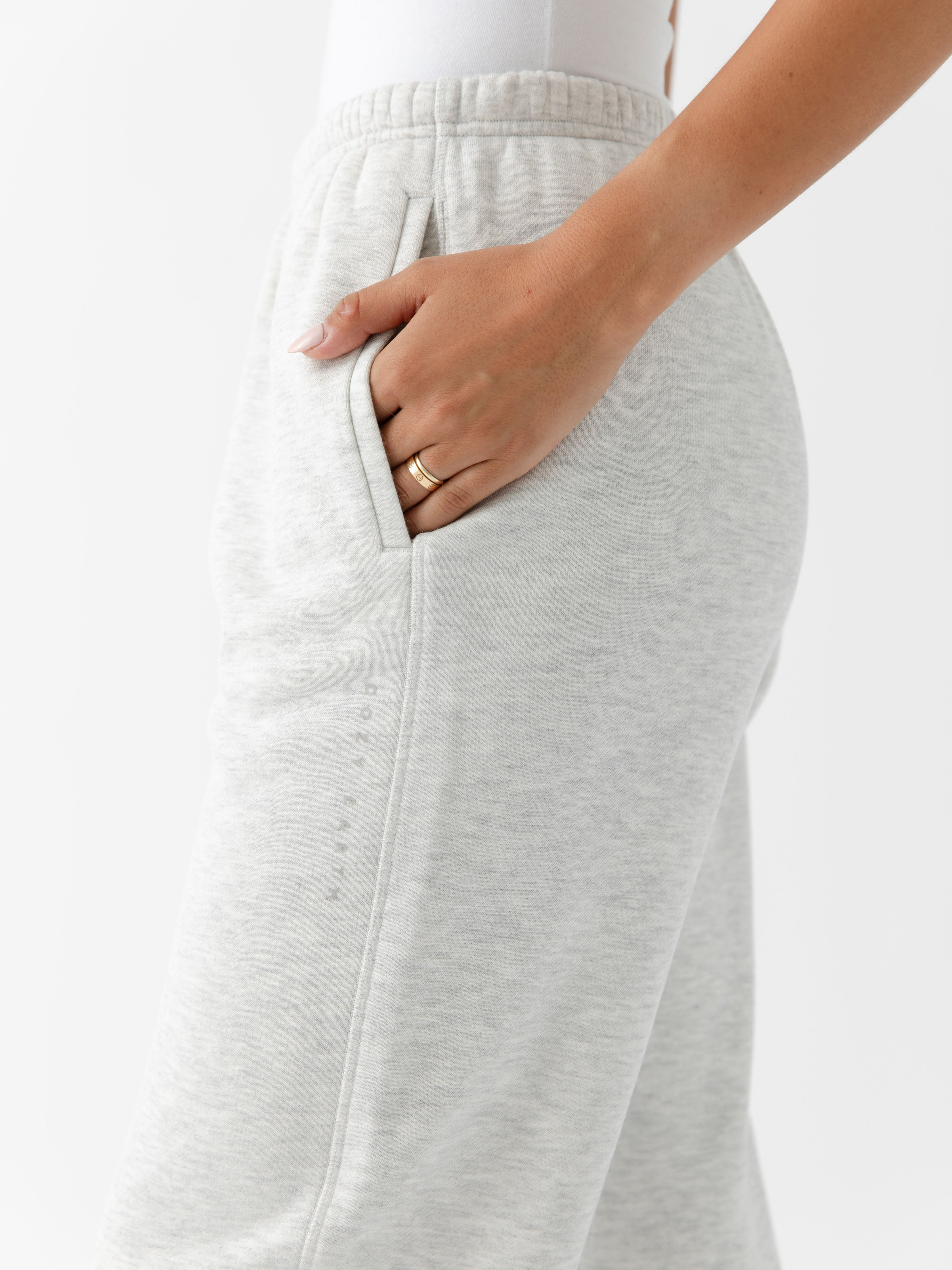 Heather Grey CityScape Joggers. The Joggers are being worn by a female model. The photo is taken from the waist down with the models hand in the pocket of the joggers. The back ground is white. 