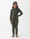 A young child smiles against a white background, wearing Cozy Earth's Children's Bamboo Waffle Knit Base Layer Set in dark green, paired with a gray beanie and gray socks with brown toes.|Color:Olive