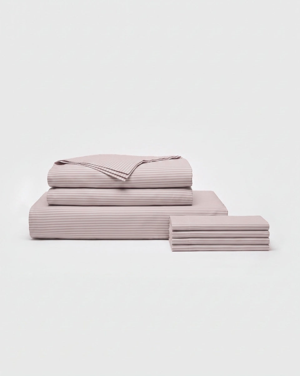 A neatly folded set of Cozy Earth Bamboo Bedding Core Bundle sheets and pillowcases, including both flat and fitted sheets, arranged against a plain white background.